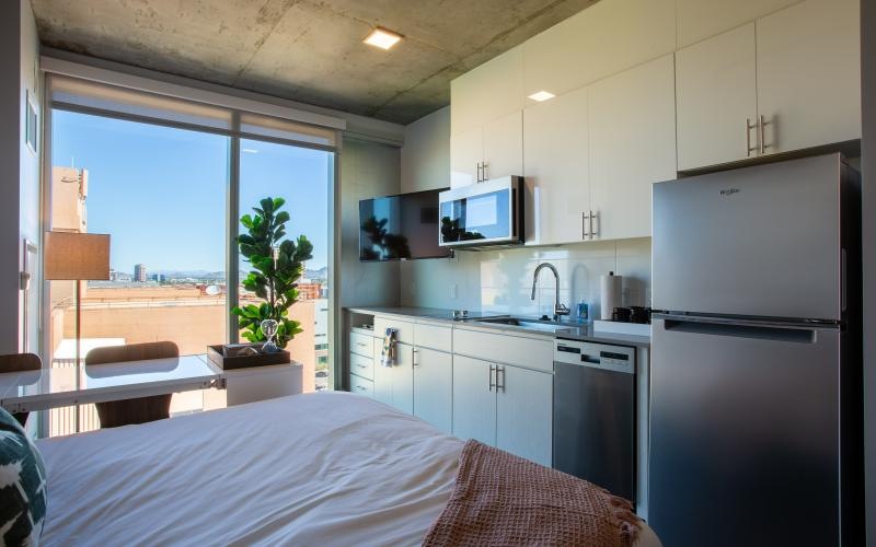 a kitchen with a bed and a refrigerator