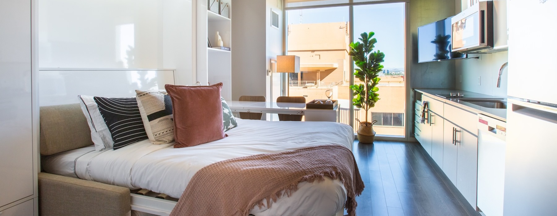a bedroom with a bed and a kitchen