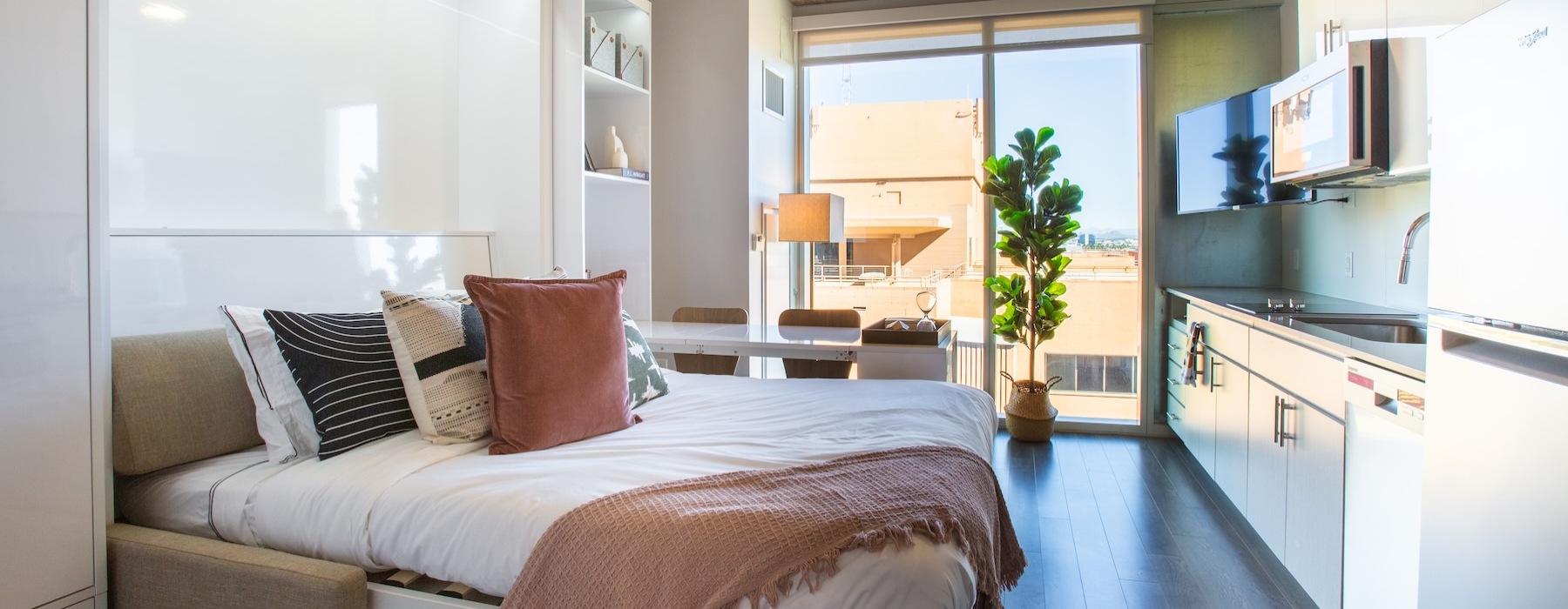a bedroom with a bed and a kitchen